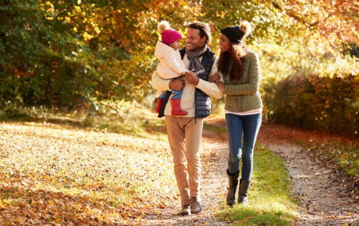 Black family with young daughter enjoying autumn countryside walk